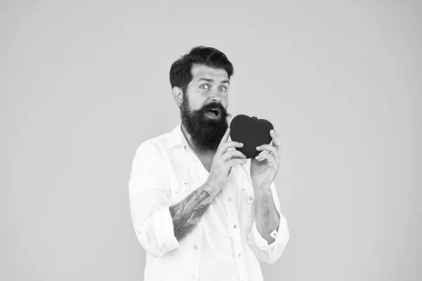 Was zu erwarten ist. bärtiger Mann rotes Herz. brutaler hipster gelber Hintergrund. Valentinstag. Herzbeschwerden und Krankheiten. Herzinfarkt vorbeugen. Verlieben. Liebe und Romantik. Organspender sein — Stockfoto