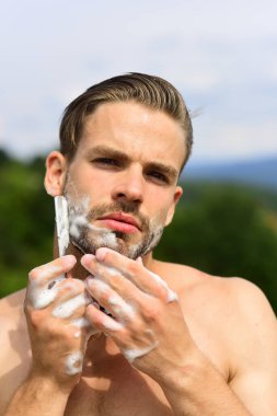 Güçlü omuzları olan, sakalını tıraş eden bir adam.