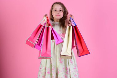 Kırmızı, pembe ve sarı paketli liseli kız alışveriş yapar.