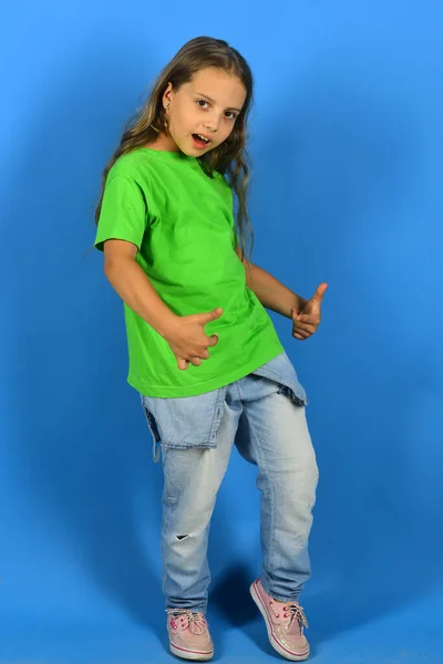 Mädchen mit stolzem Gesicht auf blauem Hintergrund — Stockfoto