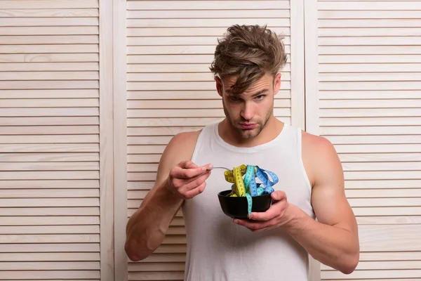 Concepto de dieta y salud. Chico comiendo cinta métrica — Foto de Stock