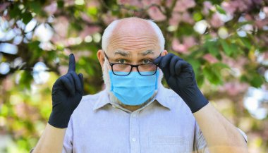 Infection is in air. Seniors vulnerable believing misinformation about covid-19. Senior man wearing face mask and gloves outdoors. Protect and from virus infection. Limit risk infection spreading clipart