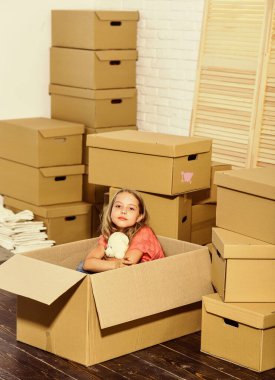 Olmak istediğin her yere yakın. Yeni bir yaşam alanı satın almak. Oyuncağı olan mutlu küçük bir kız. Taşınma konsepti. Yeni daire. Mutlu çocuk karton kutusu. Karton kutular - yeni eve taşınıyor