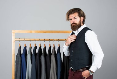 formal and office wardrobe. businessman. confident tailor designing male jacket. handsome sartor with tape measure. male beauty and fashion. bearded man tailoring clothes clipart