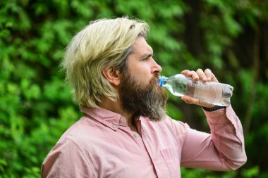 Yaz sıcağı. Temiz su içmek. Güvenlik ve sağlık. Su dengesi. Sakallı turist su içen plastik şişe doğası. Susamış adam şişelenmiş su içiyor. Sağlıklı yaşam tarzı