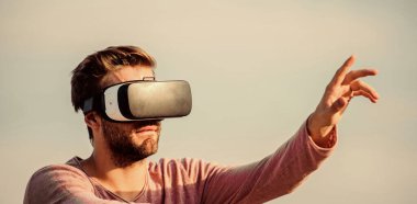 Farklı gerçeklik. erkek sanal gerçekliği. Erkek gerçekliği. Çok modern görünüyorsun. Maço adam kablosuz internet gözlüğü takıyor ve kendi işini kuruyor. Dijital gelecek ve yenilik. Seksi adam gökyüzü arkaplan gözlüğü