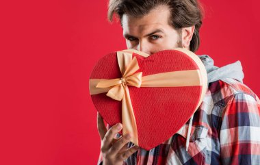 Özel bir akşam. Sevgililer günü hediyesi. Sevgilim olur musun? Acımasız yetişkin hipster kalp kutusunu tutuyor. Onun için mükemmel bir hediye. Sakallı adam sevgisini ifade eder. Bayram aşkı. Erkek alışverişe gider. Boks günü konsepti