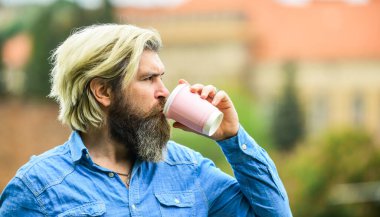 Kafe ve restoran. Güvenlik önlemleri. Kişisel fincan. Üçüncü dalga kahve. Kafein dozu. Keyfin yerinde. Sakallı bir adam kahve içiyor. Adam arka planda kahve içerken dikkati dağılmış. Kahveyi götür. Kağıt bardak.