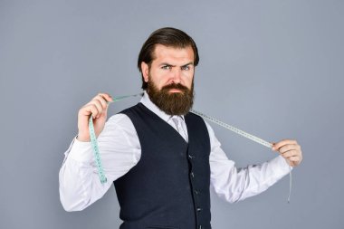 Detayları gözden geçiriyorum. Antika mobilyalarla muhteşem bir atölye. Model için özel dikim takım elbisenin portresi. İş gömleği mağazada mezura ile dikiliyordu. Beyaz gömlekli yakışıklı terzi çalışıyor.