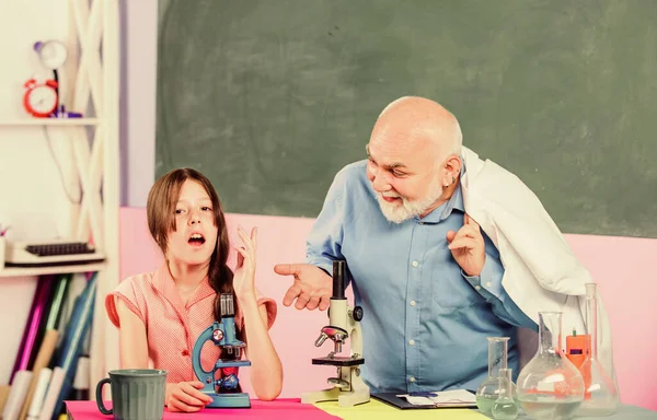 Ingeniería genética. utilizar lupa. niña pequeña con el hombre tutor estudiar química. Microscopía. Equipo de laboratorio. aula de ciencias. profesor maduro de biología. Niña en el laboratorio escolar — Foto de Stock