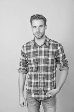 Öğrenci hayatı. Yaz ve bahar erkek koleksiyonu. Sarı arka planda kareli gömlekli yakışıklı bir adam. Seksi ve kendinden emin. Oğlan gündelik tarzda. Havalı saç stili olan berber. Gömlekli manken.