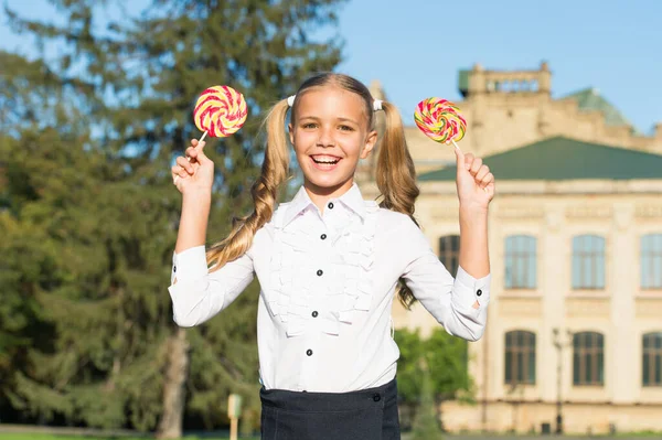 Smile maker snack. Happy kid hold lollipops outdoors. Little girl enjoy candy snack. Enjoying snack break. Unhealthy food and snacking. Diet and dieting. Sweet snack. Dessert. Candy shop
