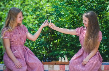 Atmosferi uyar. Eski çocukların satranç oyuncuları. Strateji kavramı. Masa oyunu. Satranç figürleriyle planlama stratejisi. Beyin gelişimi için mantık oyunu. Yarışma başarısı oyunu. İki kız parkta satranç oynuyor.