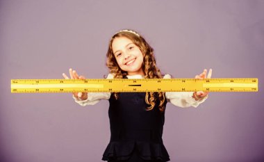 BTMM okul disiplini. Okul öğrencisi geometri öğreniyor. Küçük kız okula geri döndü. Matematik dersi. Eğitim ve bilgi. Büyük cetveli olan öğrenci kız. STEM eğitimi