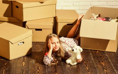 Lüks ve Konforun Gerçek Anlamı. Yeni bir yaşam alanı satın almak. Karton kutular yeni eve taşınıyor. Yeni evimizde oynuyoruz. Yeni daire. Oyuncağı olan mutlu küçük bir kız. Mutlu çocuk karton kutu
