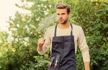 Parti devam ediyor. Açık havada et kızartmak için aletler. piknik malzemeleri. Hafta sonu dışarıda parti var. Aile hafta sonu gezisi. Yaz pikniği. Mutfak konsepti. Şef bbq yemeği pişiriyor. Man barbekü ızgarası