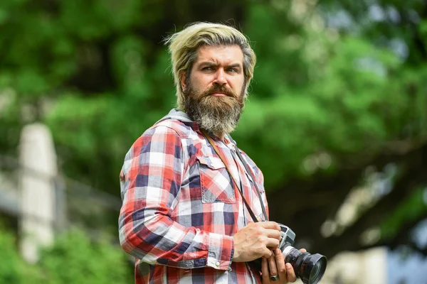 L'uomo barbuto fotografo hipster tenere fotocamera vintage. Un uomo con la barba che scatta foto. Creatore di contenuti. Un capolavoro. Concetto di fotografo. Fotografo dilettante fotografo natura sfondo — Foto Stock