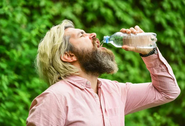 Summer heat. Drinking clear water. Water balance. Man bearded tourist drinking water plastic bottle nature background. Thirsty guy drinking bottled water. Healthy lifestyle. Safety and health — Stock Photo, Image