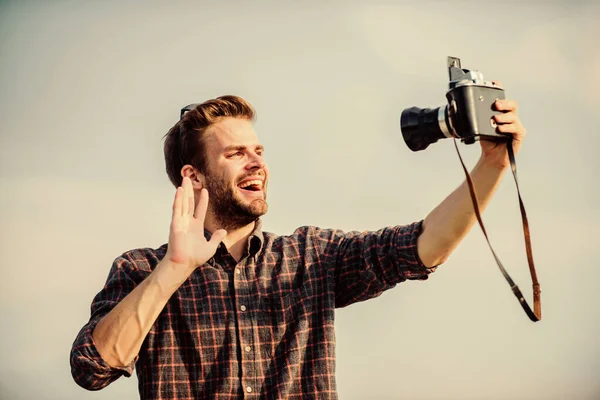 Travel blogger. Reporter taking photo. Vintage equipment. Blogger shooting vlog. Vacation time. Handsome blogger guy traveler retro camera. Guy outdoors blue sky background. Photojournalist concept — Stock Photo, Image