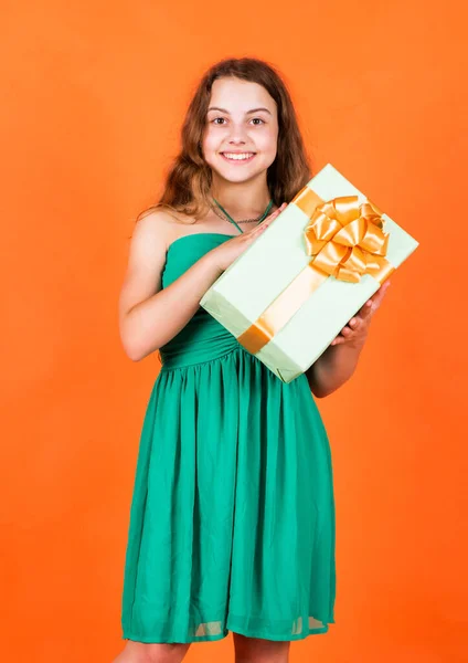 Shopping. childhood happiness. lets celebrate holiday. child in summer day on orange background. its shopping time. small girl hold present box. little kid with gift box. happy birthday party