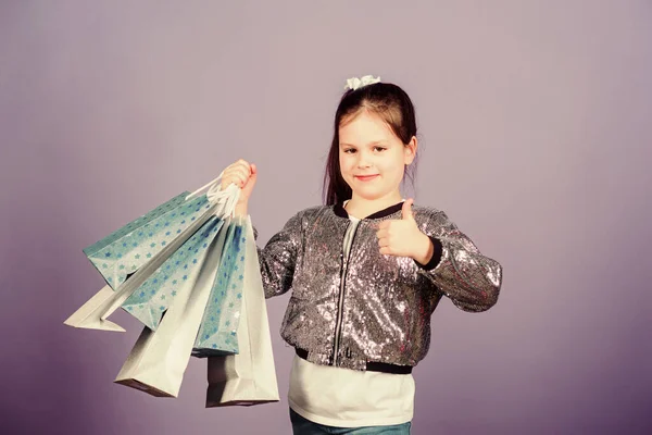 Chica con bolsas de compras fondo violeta. Compras y compras. Viernes Negro. Descuento de venta. Día de compras. Paquetes de niños. Moda infantil. Regalo sorpresa. Grandes tiendas. Grandes opciones —  Fotos de Stock