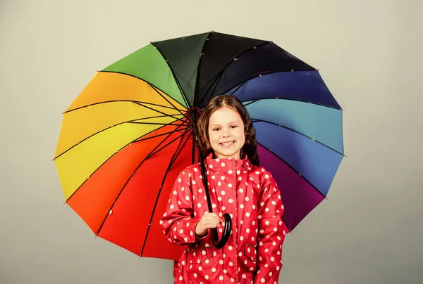화려 한 우산을 두른 행복 한 어린 소녀. 가을 패션. 쾌활하고 명랑 한 성격의 어린이. 비를 막아주는 장치. 레인보우. 비옷입은 작은 소녀. 편안하고 유행같은 느낌 — 스톡 사진