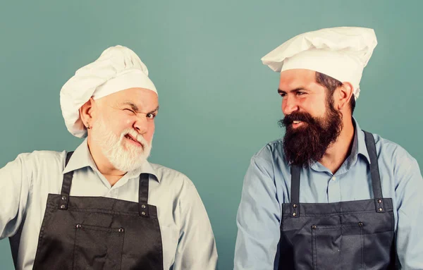 Family restaurant. Mature bearded men professional restaurant cooks. Chef men wear aprons. Cafe workers. Restaurant kitchen. Culinary industry. Restaurant staff. Father and son culinary hobby