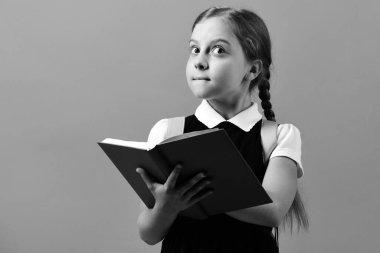 Okula ve eğitim konseptine geri dönmek. Kız mavi kitabı tutuyor.