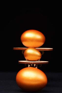 Tahta masaya altın rengine boyanmış geleneksel yumurta.