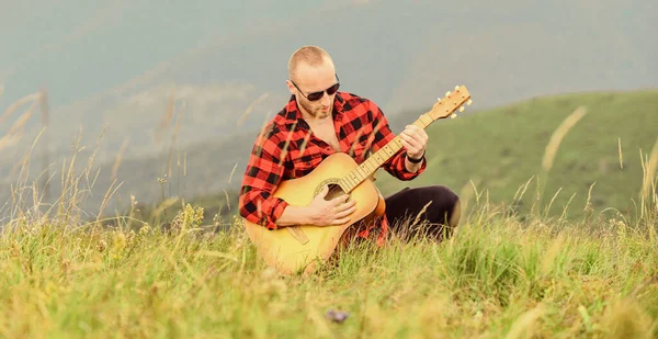 Keep calm and play guitar. Man with guitar on top of mountain. Acoustic music. Music for soul. Playing music. Sound of freedom. In unison with nature. Musician hiker find inspiration in mountains