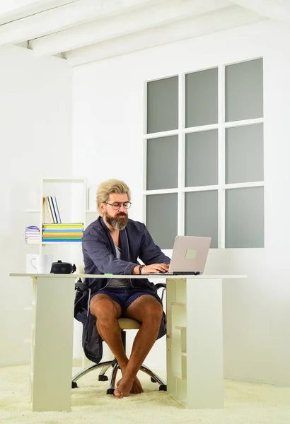 Online business. Hipster man tousled hair unshaven face using laptop. Loneliness lack human interaction. Online video conference. Guy in bathrobe resting at home. Remote job. Online communication