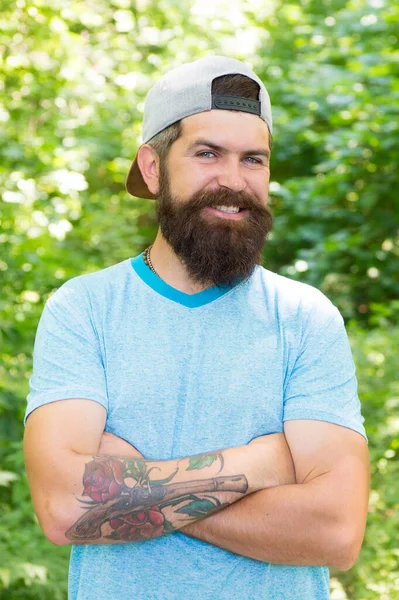 Lá fora é o novo interior. homem barbudo feliz sorrindo. retrato de moda do homem barbudo. Um tipo maduro de chapéu. Viajante hipster alegre. De pé sozinho na floresta ao ar livre com a natureza do pôr do sol no fundo — Fotografia de Stock