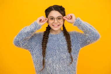 Önemli olan şeye odaklan. Neşeli gençlerin görüşü kötüdür. Saçları örgülerle örülmüş. Gözlüklü küçük güzellik. Mutlu çocukluk. Küçük kızın güzel bir gülümsemesi var. Çocuk saç stili. Uzun saçlı, gülümseyen çocuk.
