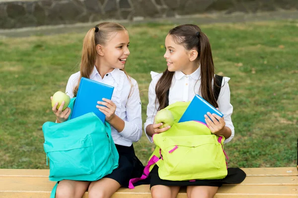 Refeição pausa no ar fresco. Miúdos felizes tiram maçãs dos sacos da escola. As meninas gostam de férias escolares ao ar livre. Alimentação saudável e lanches. Pausa natural para lanches. Alimentação e nutrição. Pausa para almoço — Fotografia de Stock