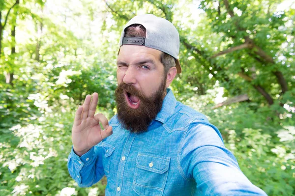 Masculin montrent ok geste. brutal hipster en forêt. découvrir de nouveaux endroits. C'est l'heure du pique-nique. caucasien avec moustache. homme barbu mature faire selfie. vacances d'été camping. homme hipster randonnée — Photo