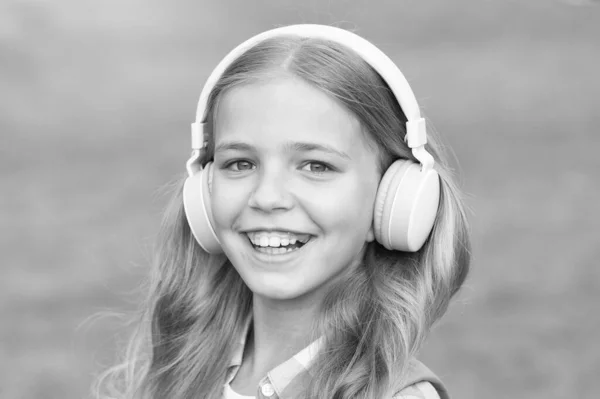 Música é vida. Criança feliz ouvir música ao ar livre. A menina usa auscultadores a tocar música. Lição musical. Nova tecnologia. Vida moderna. Ouça e aprenda. Diversão e entretenimento — Fotografia de Stock