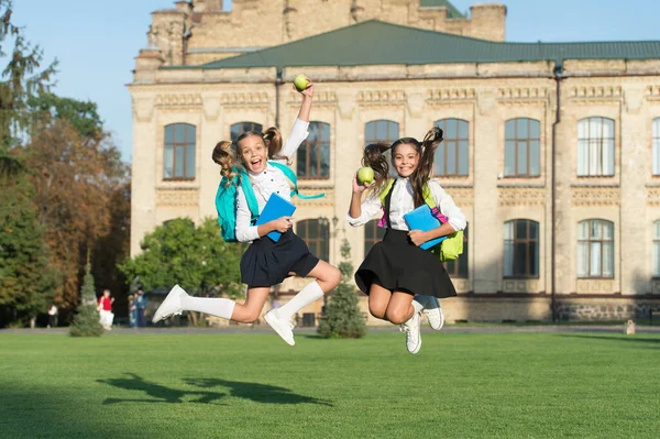 Getrieben und energisch. Energetische Kinder in der Mittagspause im Freien. Schülerinnen im energiegeladenen Sprung. Zurück zur Schulmode. Schuljause. Energetische Ernährung. Nahrung spendet Energie. Gesund und aktiv — Stockfoto