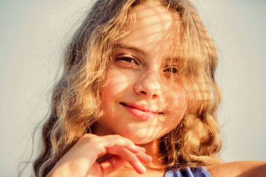 Kendine iyi bak. Güneş kremi sür. Kız dışarıda dinleniyor. Uv filtresi güneş kremi. Kendine iyi bak. Yaz bakımı. Güneş kremi. Sıcak güneş ışığından memnun olan çocuk rahat mavi gökyüzü arkaplanına benziyor