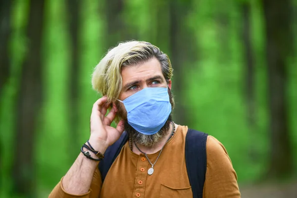 Stop infectie. Kom langzaam uit de beperkingen van de vergrendeling. Loop in het park. Vermijd infectie. Hipster beschermt tegen luchtverontreiniging of coronavirus. Virusinfectie. Man geniet van de natuur met gezichtsmasker — Stockfoto