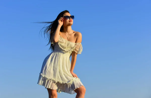 Vento di cambiamento. Modello di fantasia in tenero abito estivo. Verso l'estate. Libertà e armonia. Psicologia femminile. Bella donna nella giornata di sole cielo blu. Moda estiva. Ragazza in occhiali da sole copia spazio — Foto Stock