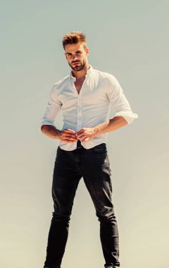 Açık havada sıcak bir gün. Yakışıklı bir manken. Seksi maço adam. Sıcaklık mevsimi. Resmi moda. Resmi tarz. Çekici bir adamın gömleğini çıkarması. Cazibesine güveniyor. Sakallı adam iş stili.