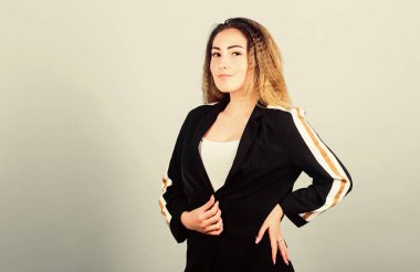 Zarif ve atletik parçaları karıştırıyorum. Spor kıyafetleri podyumlarda kural koyuyor. Voluminous kıvrımlı saç stili. Moda kıvrımlı saç stili. Şık spor. Mavi arka planda, gülümseyen yüz stili saç stili