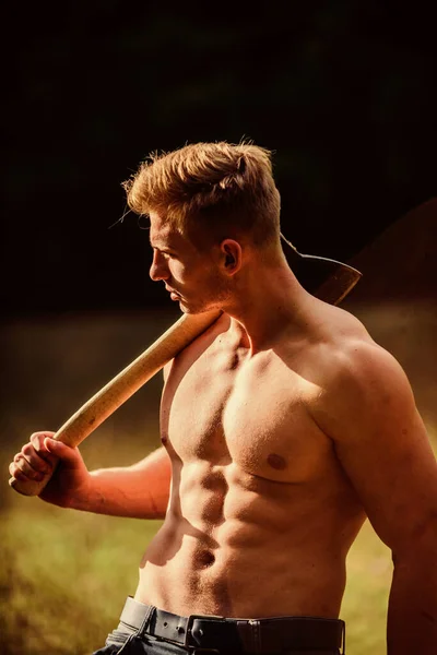 힘 과 힘의 개념. 도끼를 든 포스터. 섹시 한 남자는 토르소를 입었고. 야생에서 생존하는 거죠. 숲 속의 근육 운동 선수. 운동 과 체력. 근육질의 몸. 털없는 남자의 근육질 몸매 — 스톡 사진