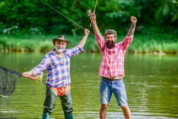 Vacanze estive. Felice gente allegra. Pescatore con canna da pesca. Attività e hobby. Pesca d'acqua dolce lago stagno fiume. Uomini barbuti che catturano pesci. Padrone Baiter. Uomo maturo con amico pesca — Foto Stock