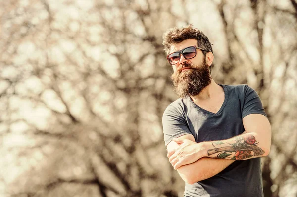 Bearded man wear modern fashionable sunglasses. UV filter. Man bearded with sunglasses nature background. Bearded hipster brutal man wear protective sunglasses. Hipster confident in dark sunglasses