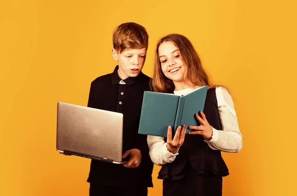 Studienmöglichkeiten. Kleine Kinder lernen gerne zusammen. Kleine Mädchen und Jungen halten Buch und Laptop in der Hand. Studieren für Prüfungen. Lernen und Lernen. Bildung und Schule — Stockfoto