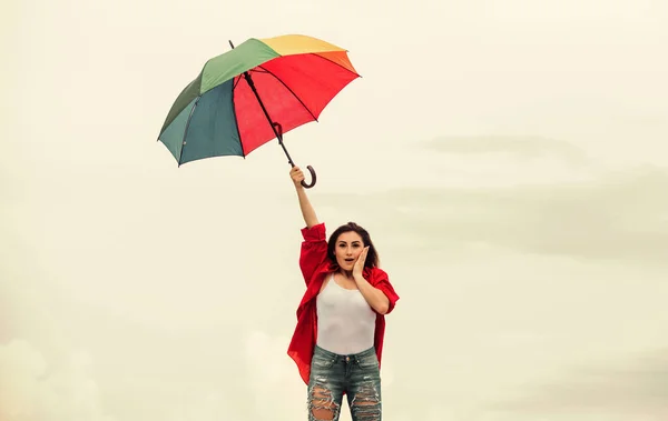 Easy and free. Good weather. Welcoming fall. Pretty woman with colorful umbrella. Rainbow umbrella. Rainy weather. Good mood. Good vibes. Open minded person. Girl feeling good sky background