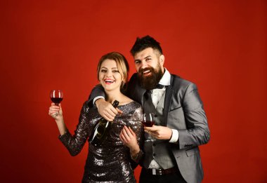 Aşık bir çift kırmızı arka planda gözlük tutuyor.