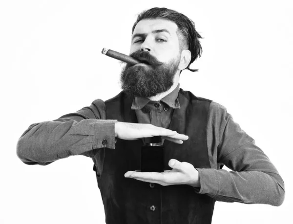 Homem barbudo fumar charuto com rosto sério, segurando perfume — Fotografia de Stock