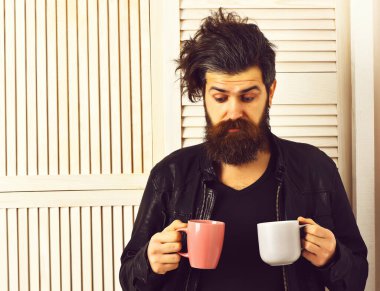 Kafkasyalı vahşi hippi elinde bardak ya da kupa tutuyordu.